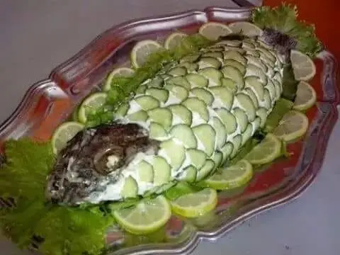 Decorated whole fish with cucumber and lemon — African catering display Gaithersburg